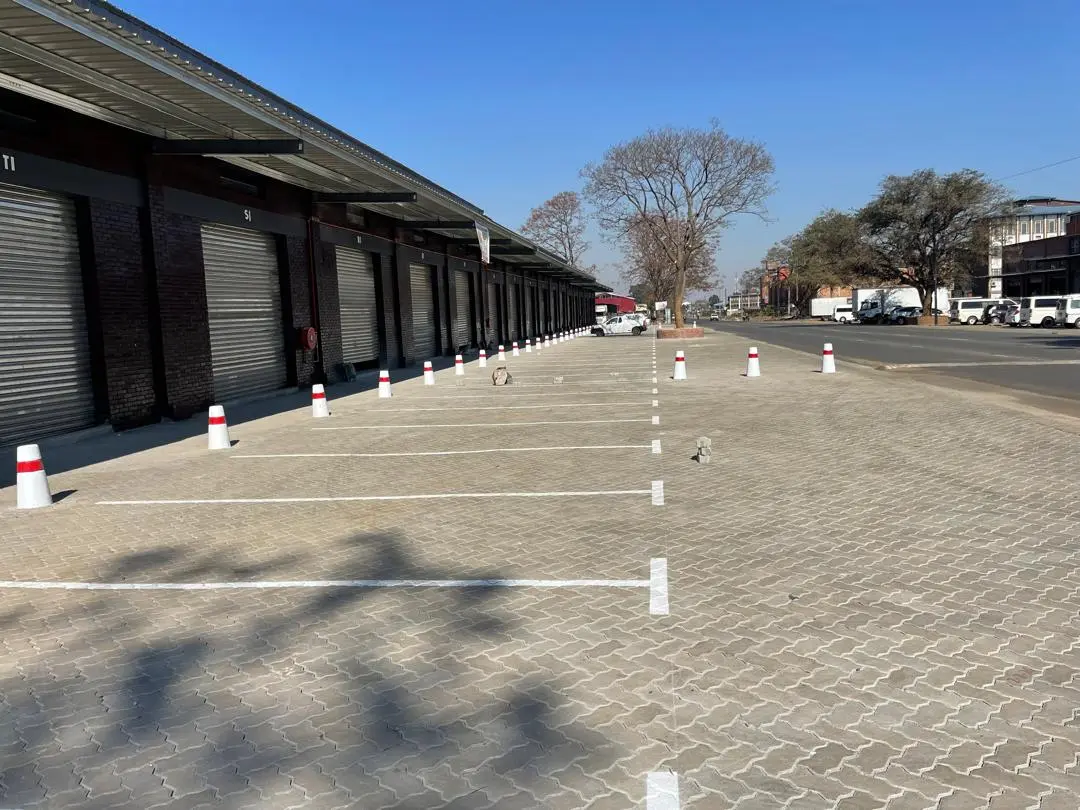 Completed paved parking bays alongside a row of commercial buildings